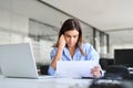 Busy professional mature business woman reading bad news in document at work. Royalty Free Stock Photo