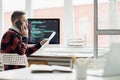 Busy programmer talking to customer by phone