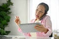 Busy senior Asian businesswoman is talking on the phone with her client Royalty Free Stock Photo