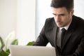 Busy serious businessman focused on working with laptop computer