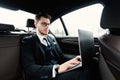 Busy serious businessman using his laptop in luxury car Royalty Free Stock Photo