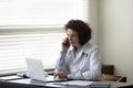 Busy serious mature female chief doctor speaking on mobile phone Royalty Free Stock Photo