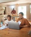 Busy, serious and multitask mother working on laptop while taking care of her child at home. Black entrepreneur or Royalty Free Stock Photo