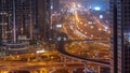 Busy Sheikh Zayed Road aerial all night timelapse, metro railway and modern skyscrapers around in luxury Dubai city.