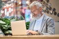 Busy older senior business man using laptop working late on computer. Royalty Free Stock Photo