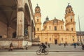 Busy square Odeonsplatz with bicyclists and pedestrians near historical structures