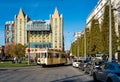 Busy street in the center of Antwerp with old tram and parked taxi cars, exterior of iconic Radisson Blu hotel in the background