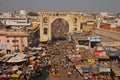 Busy street with a large arch nearby the iconic Charminar