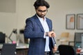 Busy indian business man checking time looking at watch in office. Royalty Free Stock Photo