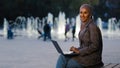 Busy successful muslim student girl in hijab young islamic business woman using laptop app working in city fountains