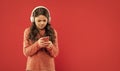 busy teen girl in sweater in headphones for listening music texting in phone, copy space, technology