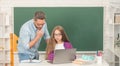 busy teen girl and teacher man in high school with pc at blackboard, back to school