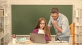 busy teen girl and teacher man in high school with pc at blackboard, back to school