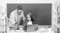 busy teen girl and teacher man in high school with pc at blackboard, back to school