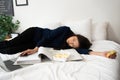 Busy and tired businesswoman eating bread for breakfast in bed at home and working to deliver financial statements to a boss. Royalty Free Stock Photo