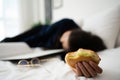 Busy and tired businesswoman eating bread for breakfast in bed at home and working to deliver financial statements to a boss. Royalty Free Stock Photo