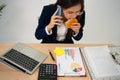 Busy and tired businesswoman eating Bread and milk for lunch at the Desk office and working to deliver financial statements to a Royalty Free Stock Photo