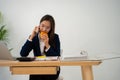 Busy and tired businesswoman eating Bread and milk for lunch at the Desk office and working to deliver financial statements to a Royalty Free Stock Photo