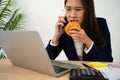 Busy and tired businesswoman eating Bread and milk for lunch at the Desk office and working to deliver financial statements to a Royalty Free Stock Photo