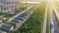 Busy traffic on Interstate 10 highway near Lake Barrington early morning along row of townhouses, condos, lush green trees and