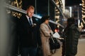 Busy urban evening scene with people waiting at a bus stop in winter. Royalty Free Stock Photo