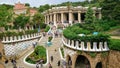 A busy view of tourists walking on the monumental and colourful Dragon Stairway in Parc Guell