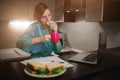 Busy woman eating, drinking coffee, talking on the phone, working on a laptop at the same time. Businesswoman doing Royalty Free Stock Photo