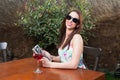 Busy woman having wine on terrace holding tablet Royalty Free Stock Photo