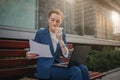 Busy woman is in a hurry, she does not have time, she is going to eat snack outdoors. Worker eating and working with Royalty Free Stock Photo