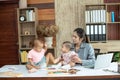 Busy woman trying to work while babysitting two kids.  Young Asian mother talking and playing with two children playing around her Royalty Free Stock Photo