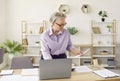 Serious mature businesswoman working in her office, doing paperwork and using laptop Royalty Free Stock Photo