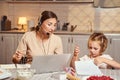 Girl drawing in notepad while mother working remotely on laptop Royalty Free Stock Photo