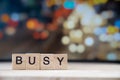 busy word Written In Wooden Cube on wood table with traffic bokeh in background Royalty Free Stock Photo