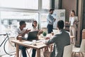 Busy working day. Two young colleagues conducting a business presentation using flipchart while working in the creative office Royalty Free Stock Photo