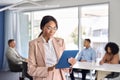 Busy young African American business woman using tab standing at office meeting. Royalty Free Stock Photo