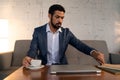 Busy young businessman having coffee and doing his work. Royalty Free Stock Photo