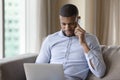 Busy young freelance professional man talking on mobile phone