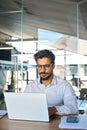 Busy young Latin business man looking at laptop using computer at work. Royalty Free Stock Photo