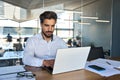 Busy young Latin business man looking at laptop using computer at work. Royalty Free Stock Photo