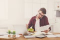 Busy young man has business lunch in modern office interior Royalty Free Stock Photo