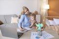 Busy mother with baby on her lap having phone conversation Royalty Free Stock Photo