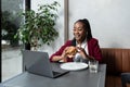 Busy young professional business woman wearing suit using laptop computer sitting in cafe restaurant. Hungry manager remote