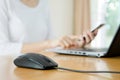 Busy young woman is typing on laptop computer and using mobile p Royalty Free Stock Photo