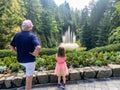 A little girl and her grandpa admiring a beautiful water fountain and Butchart Gardens, in Brentwood Bay, Vancouver Island, Canada Royalty Free Stock Photo