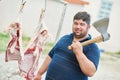 Butcher with axe and sheep carcass meat