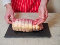 Butcher checking out eye of round roast of beef on a black slate board and simple white table cloth, Concept meat industry, Royalty Free Stock Photo