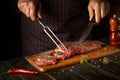 Butcher or chef preparing raw fresh beef meat on cutting board before baking or barbecue. Recipe idea for a restaurant or hotel Royalty Free Stock Photo