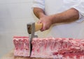 Butcher with a chisel handles raw pork Royalty Free Stock Photo