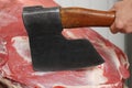 Butcher chopping fresh raw meat with axe in shop