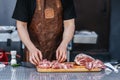 Butcher, cook cutting beef for barbeque grill, piece of raw beef meat close-up. Preparation of meat, recipes and menus